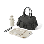 Black duffel bag with beige drawstring bag, pouches, and utensils on a white background